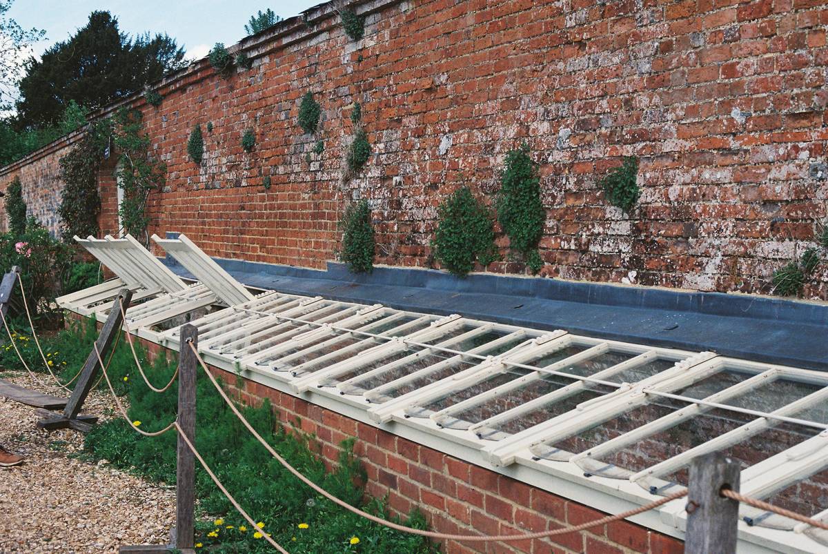 Wooden garden cold frames for plants protecting young lettuce and spinach in early spring